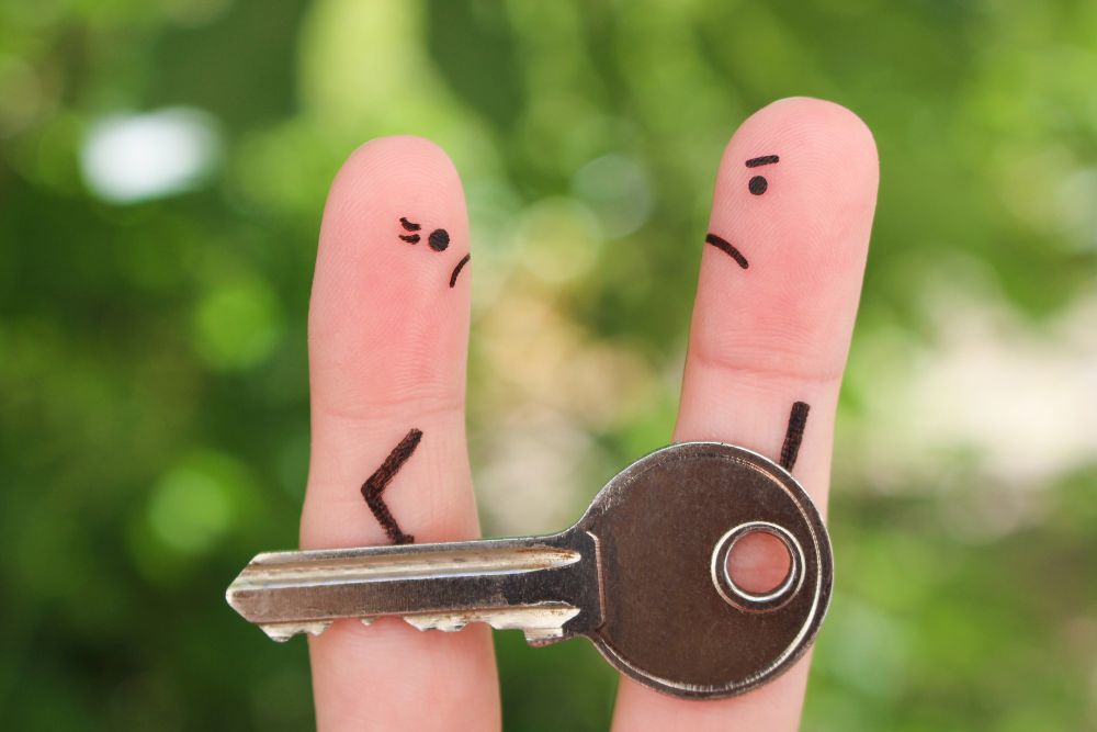 Two finger people fighting over a key to a house